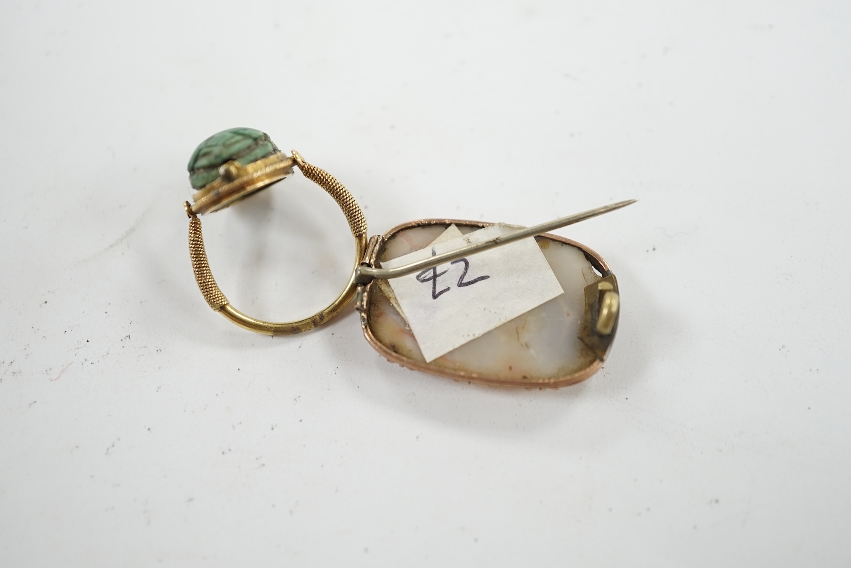 An antique yellow metal 'Scarab' ring and a banded agate set brooch. Condition - poor to fair